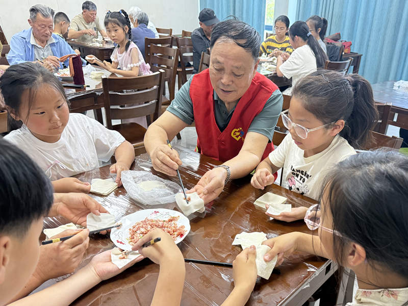 许村镇杨渡村老年学堂开展“老少共学包馄饨”主题活动